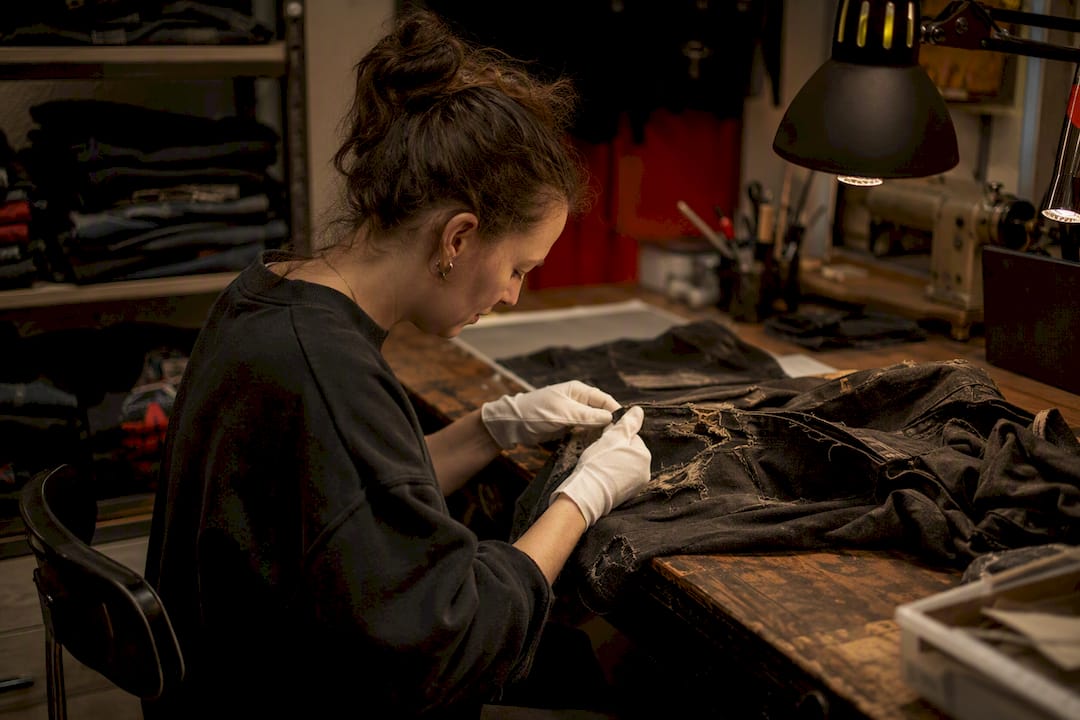Conservator handling vintage metal shirt fabric