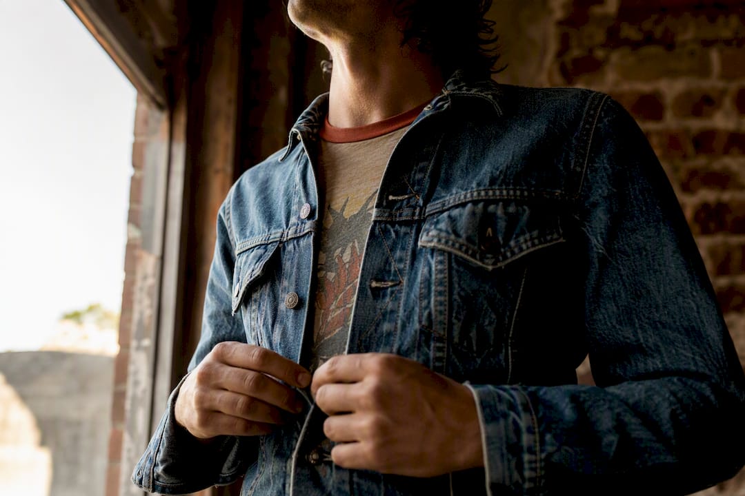 Layered vintage ringer tee under denim jacket detail