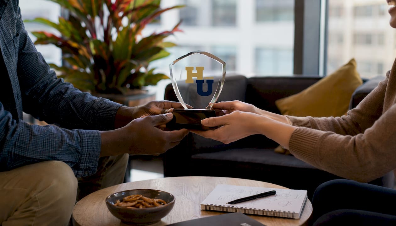 Award plaque handed between coworkers close-up