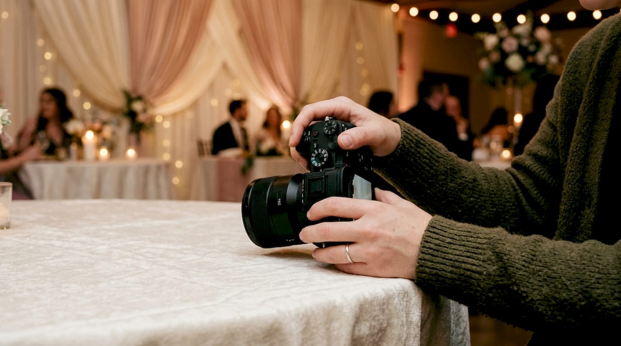 Venue photography tips for wedding photographers 2 Hands adjusting camera settings indoors