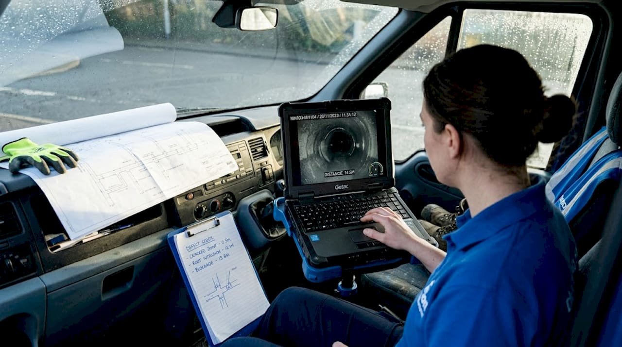 Drain engineer watching CCTV inspection footage