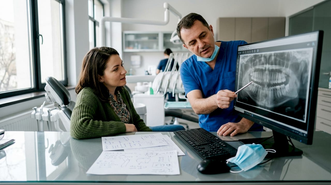 Medicul discută cu pacientul și îi explică rezultatele radiografiei panoramice.