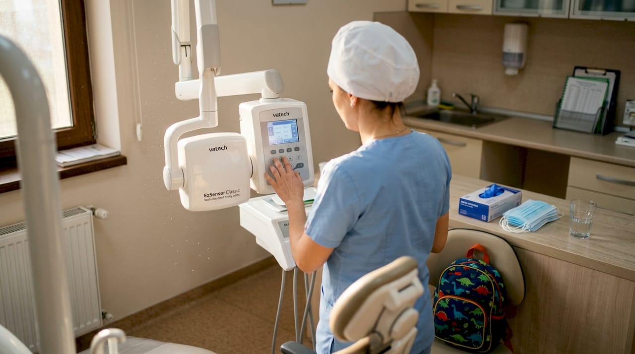 Asistenta se ocupă de pregătirea unui aparat modern pentru radiografii dentare.
