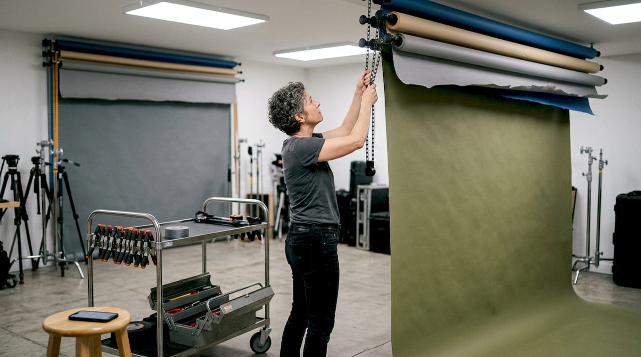 Studio assistant using ceiling roller backdrop system