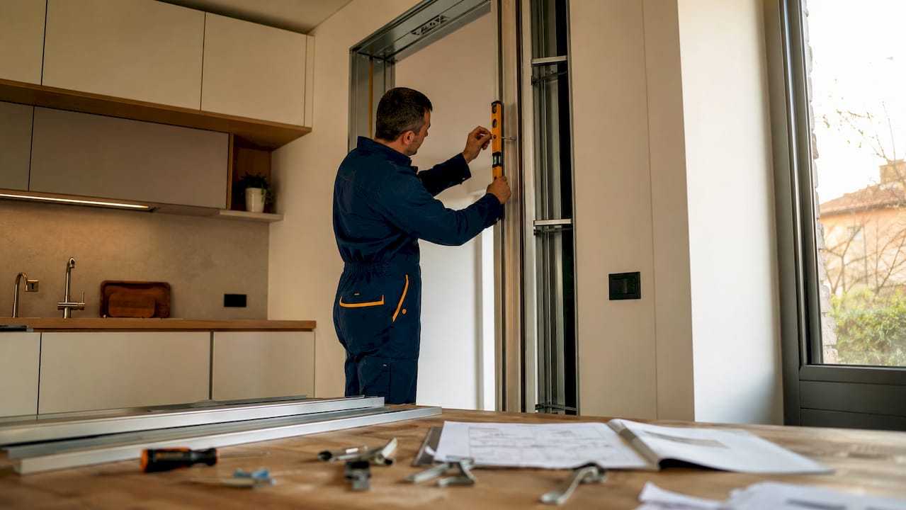 Un professionista si occupa del montaggio di una porta scorrevole a scomparsa all’interno di un’abitazione.