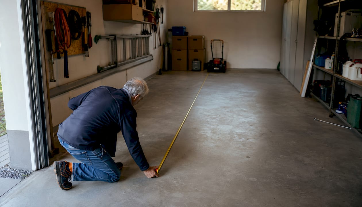 Una persona prende le misure della profondità all’interno del garage.