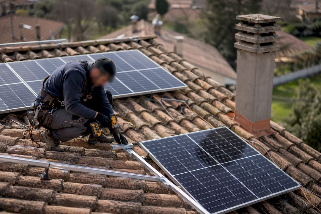 Tecnico che installa pannelli fotovoltaici sul tetto