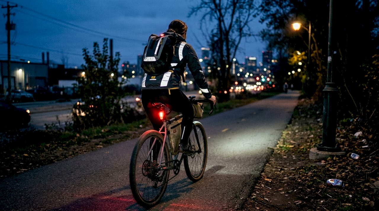 Cyclist riding with lights and reflective gear at night