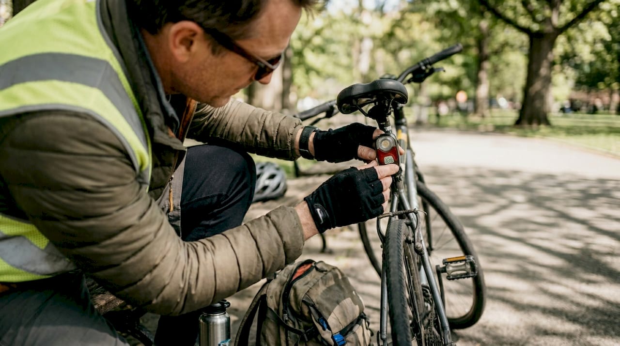 Cyclist adjusting rear radar light in park