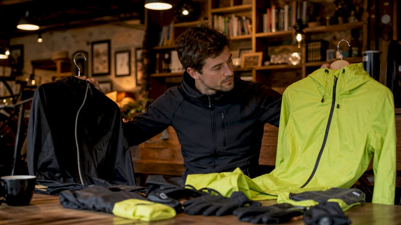 Dans son atelier, un technicien examine et compare différentes vestes imperméables pour en évaluer la qualité.