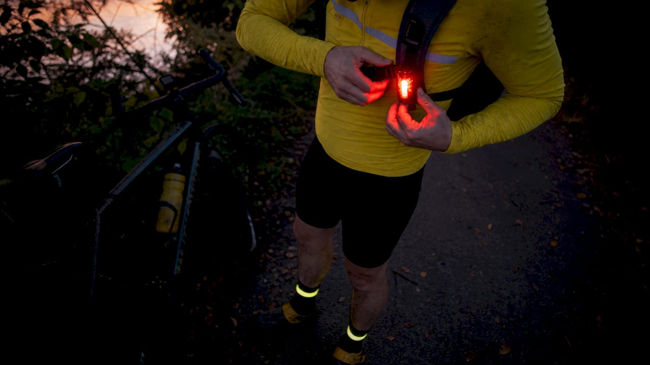 Close-up of cyclist adjusting reflective gear and light