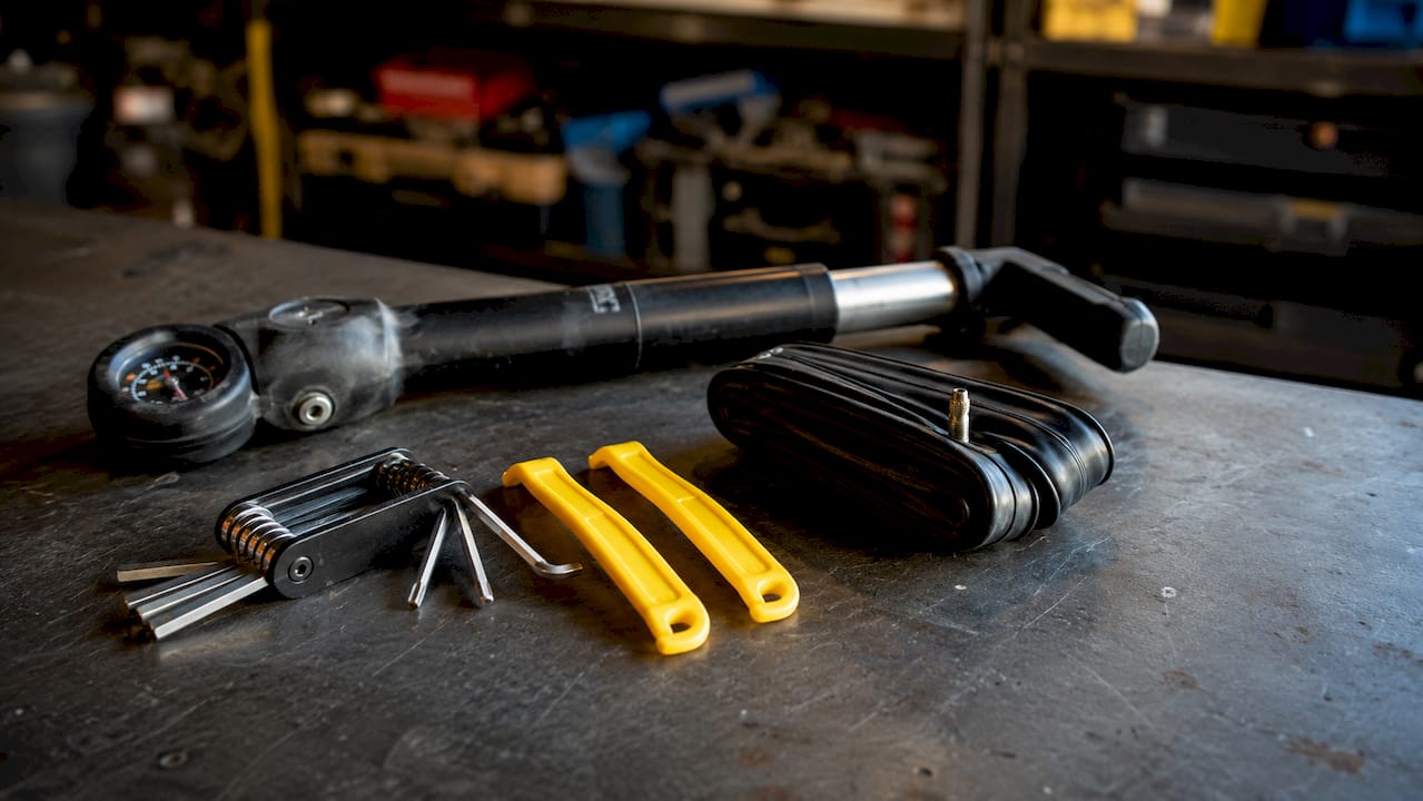 Tout le nécessaire pour réparer son vélo soigneusement disposé sur une table en bois.