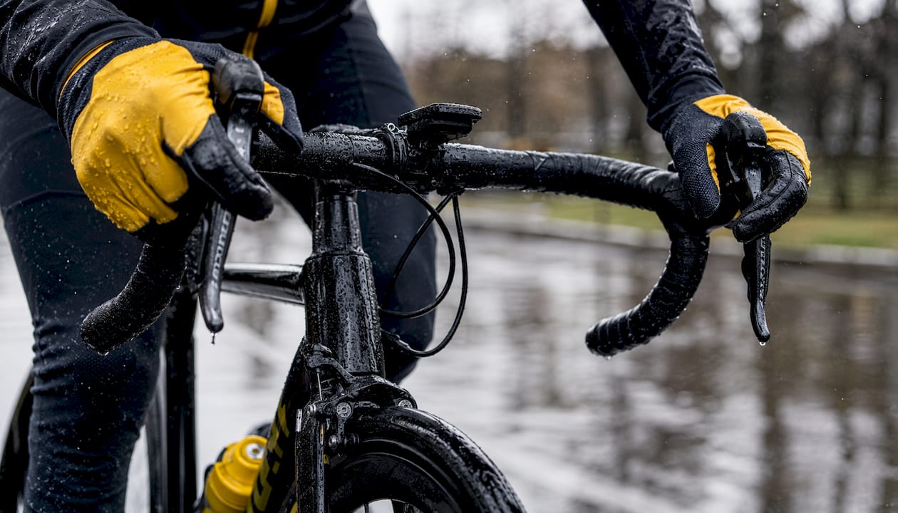 Cyclist's hands braking carefully on wet road