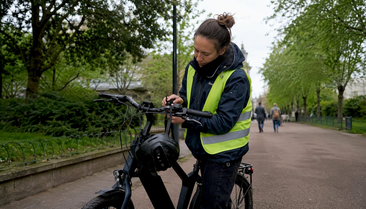 Une femme s’apprête à enfourcher son vélo électrique devant son lieu de travail.