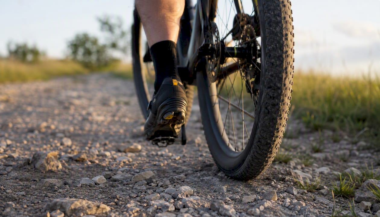 Wide gravel bike tire gripping rocky ground
