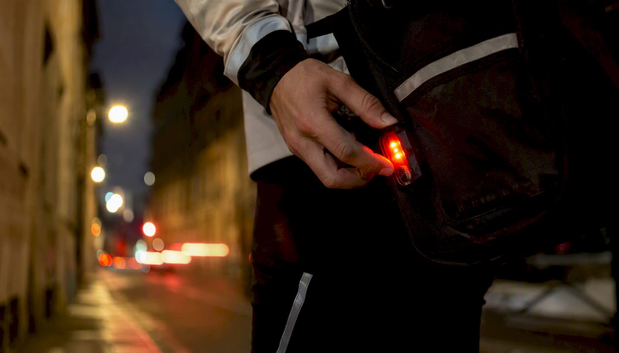 Feu arrière clignotant d’un vélo circulant en ville la nuit
