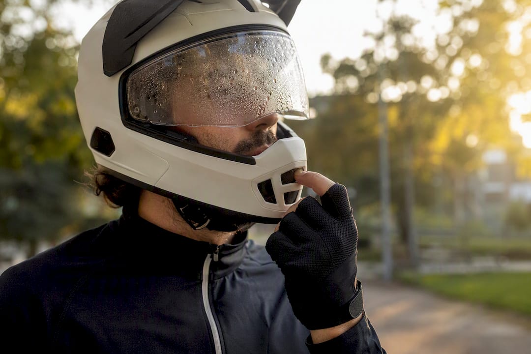 Hand opening helmet chin vent to clear fog