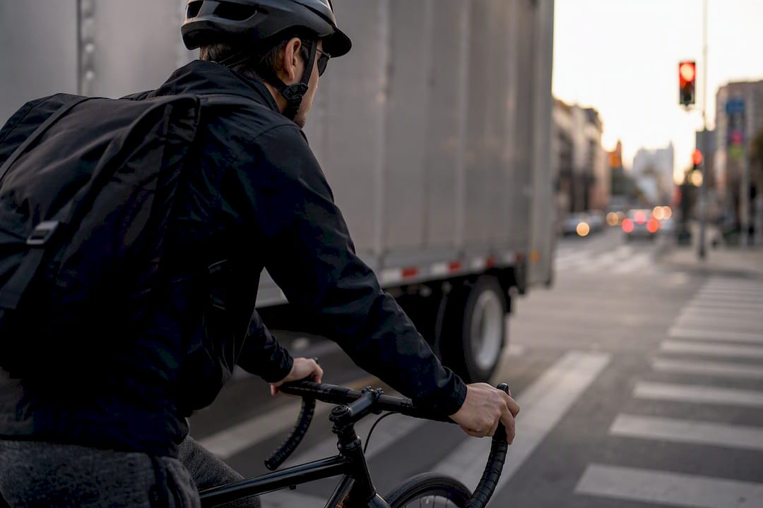 Cyclist easing pedals beside truck