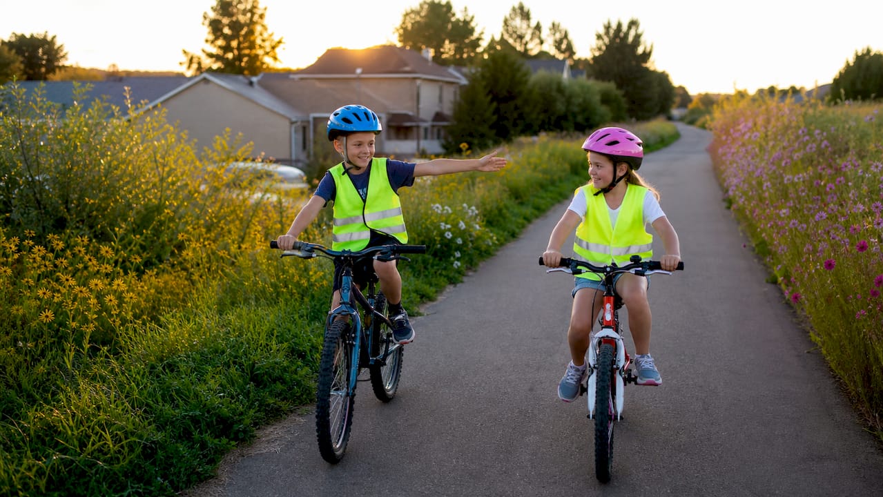 Children practicing bike hand signals on path