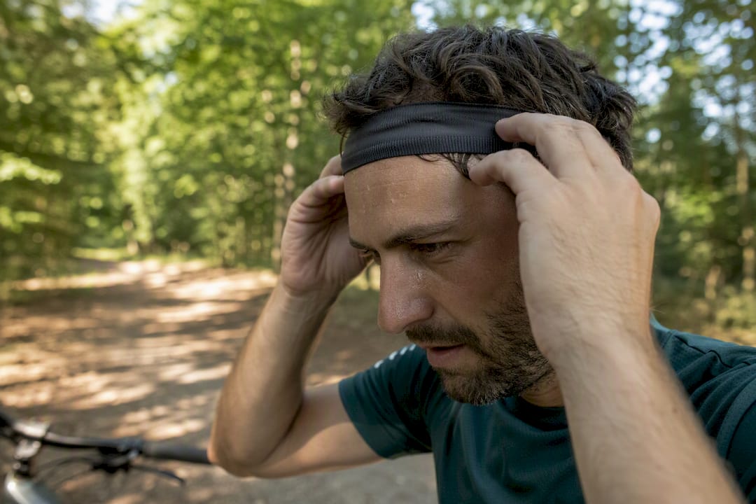 Cycliste ajustant un bandeau absorbant la transpiration