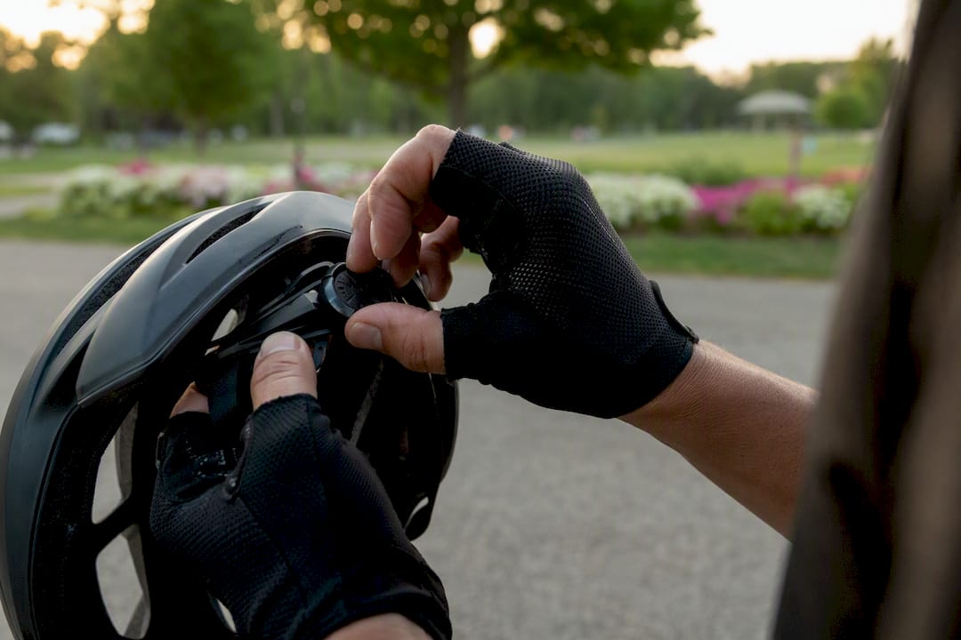 Hands adjusting helmet retention dial