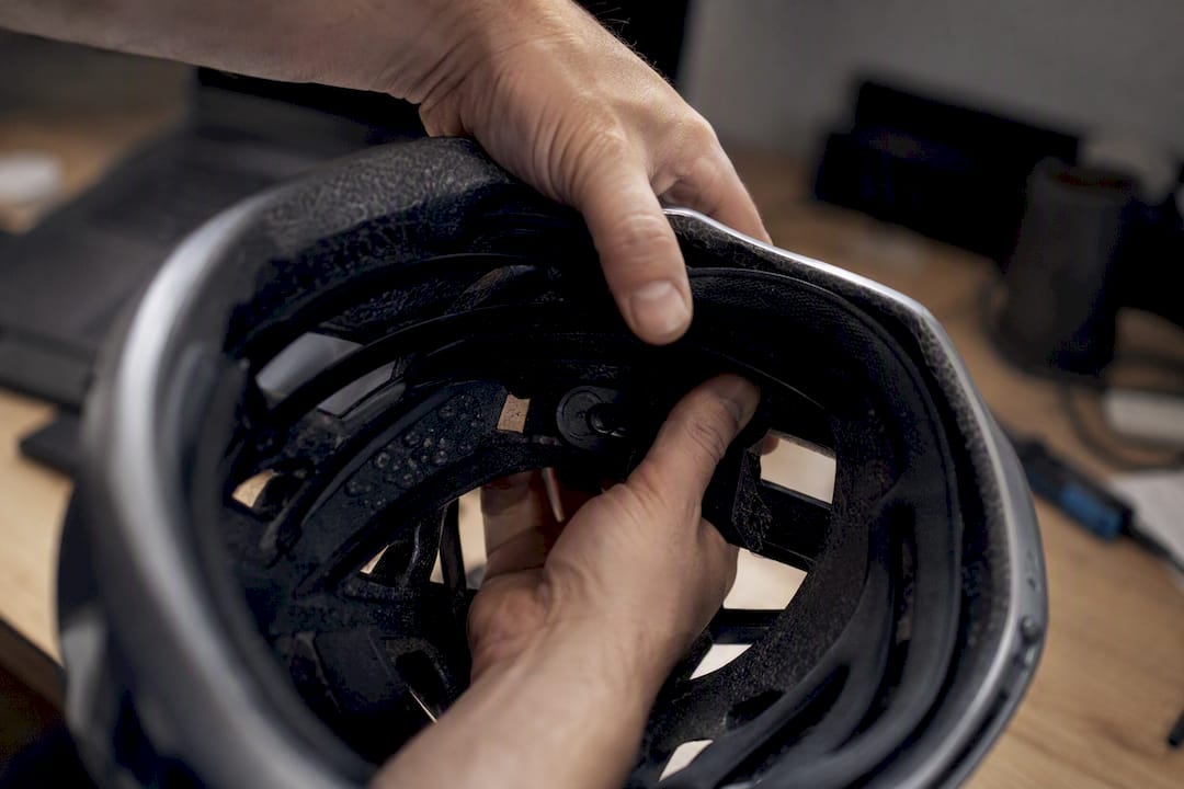 Mains testant la couche intérieure anti-rotation du casque