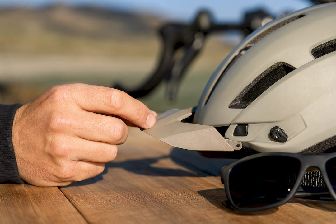 Main qui enlève une visière amovible de casque
