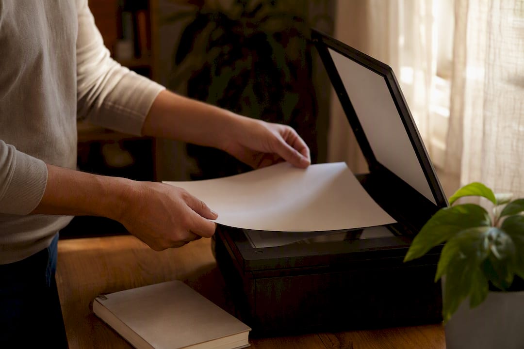 Mani al lavoro che digitalizzano documenti per l’archivio elettronico.