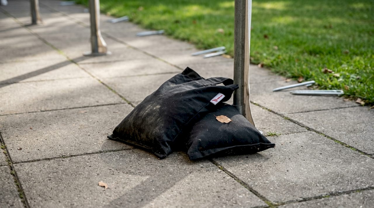 Met zandzakken aan de poten blijft de tent stevig staan, ook bij wind.