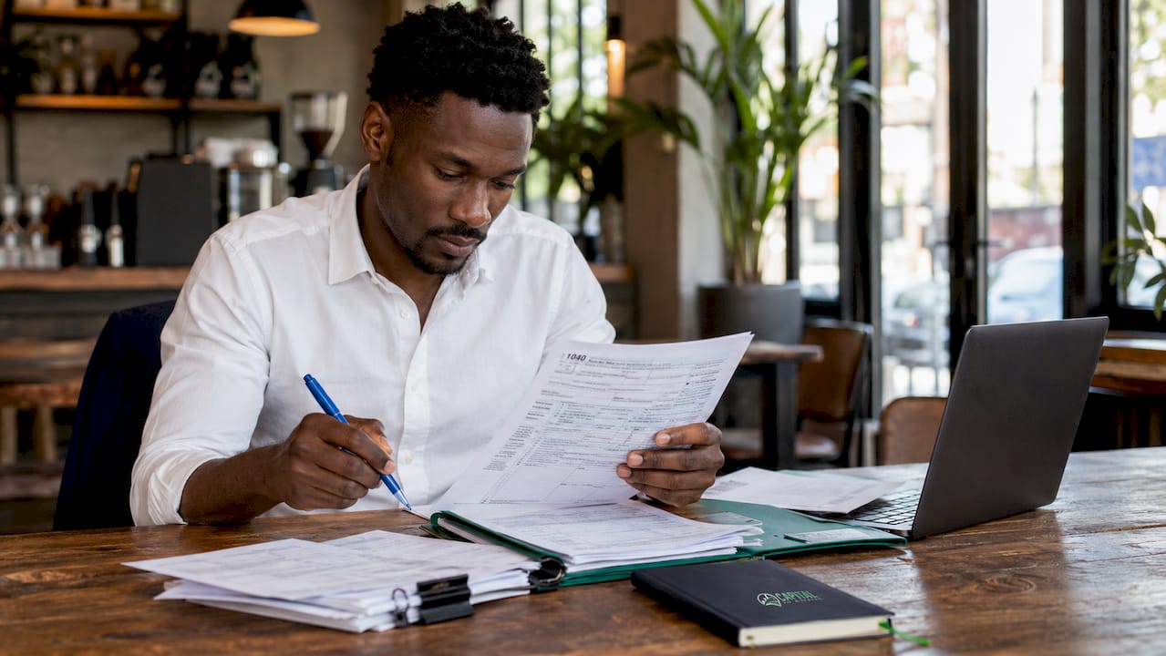 Hands sorting financial documents on desk