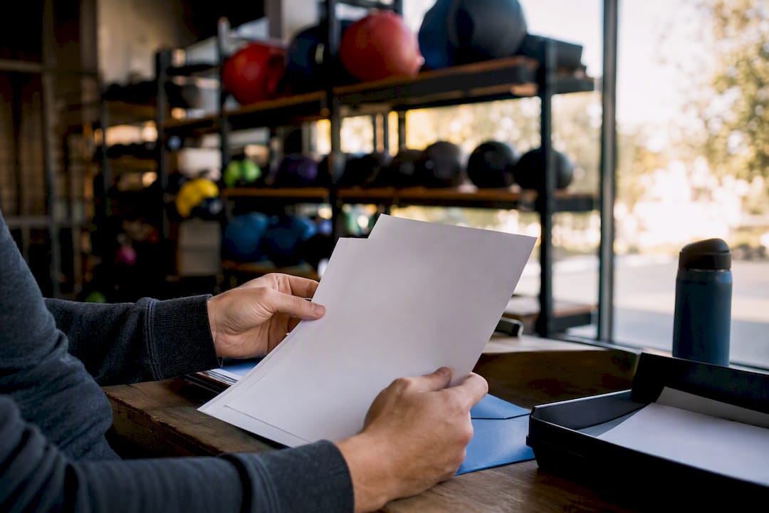 Hands filing itemized gym invoice in cabinet