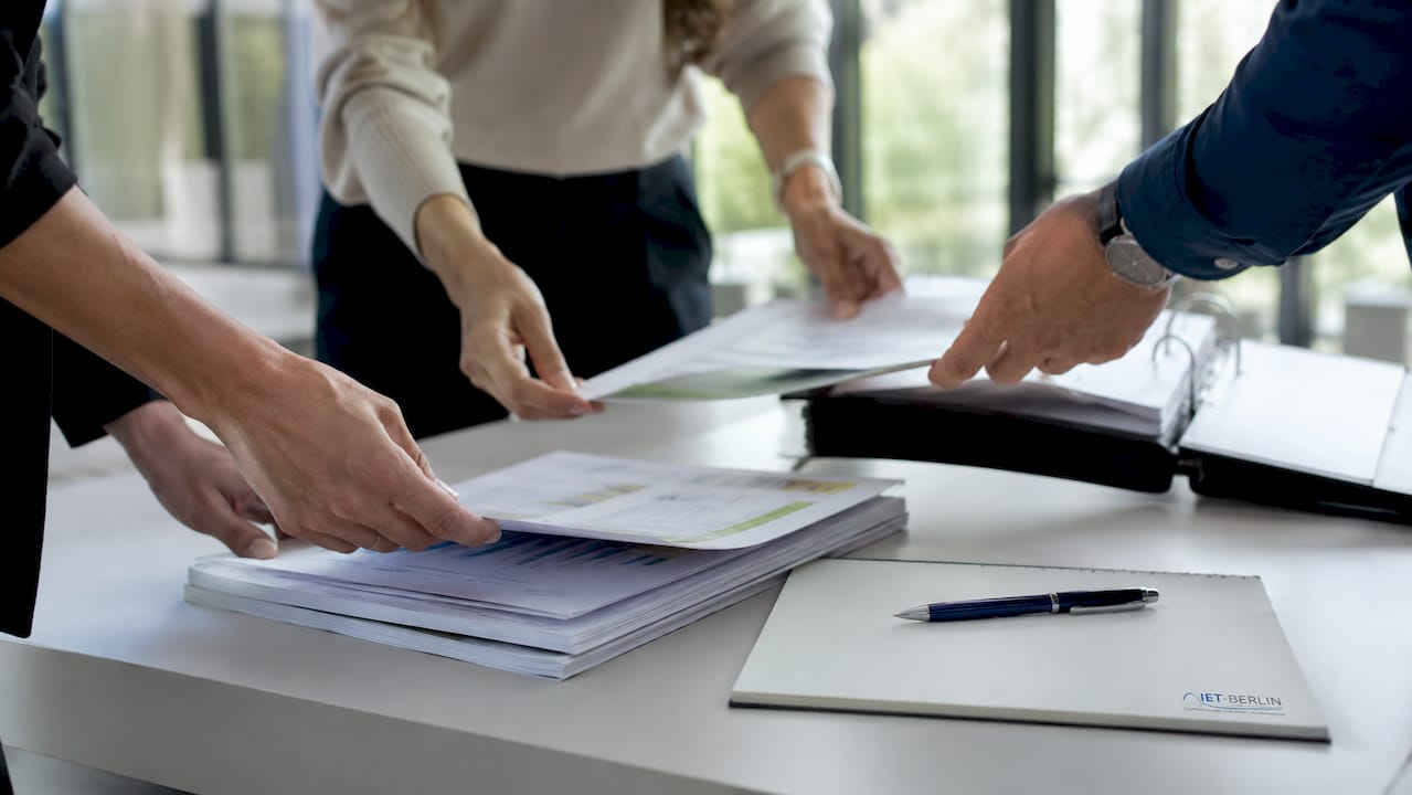 Das Team diskutiert gemeinsam am Tisch verschiedene Möglichkeiten zur Energieeinsparung und sortiert die Maßnahmen nach ihrer Priorität.