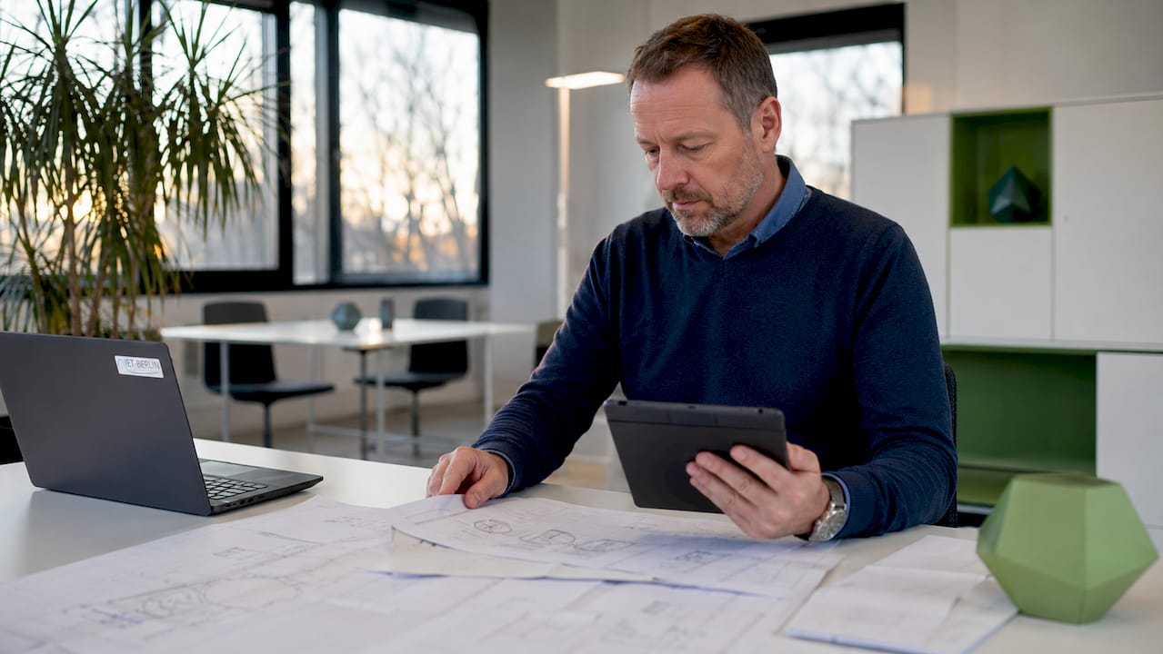 Ein Energieberater überprüft die Maschinen mithilfe eines Tablets.