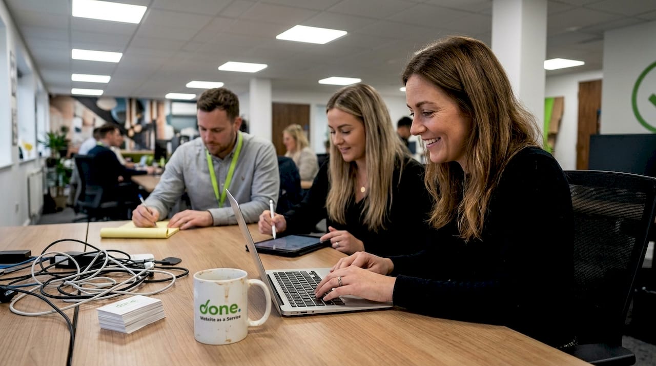 Team collaborating with laptops and tablets in office