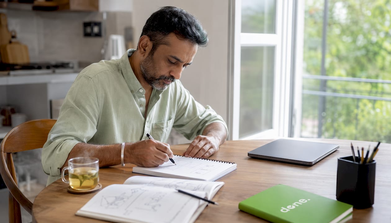 Hands writing brand promise in office