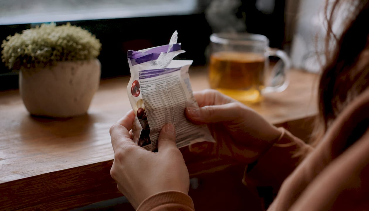 Hands reading fruit snack ingredients label