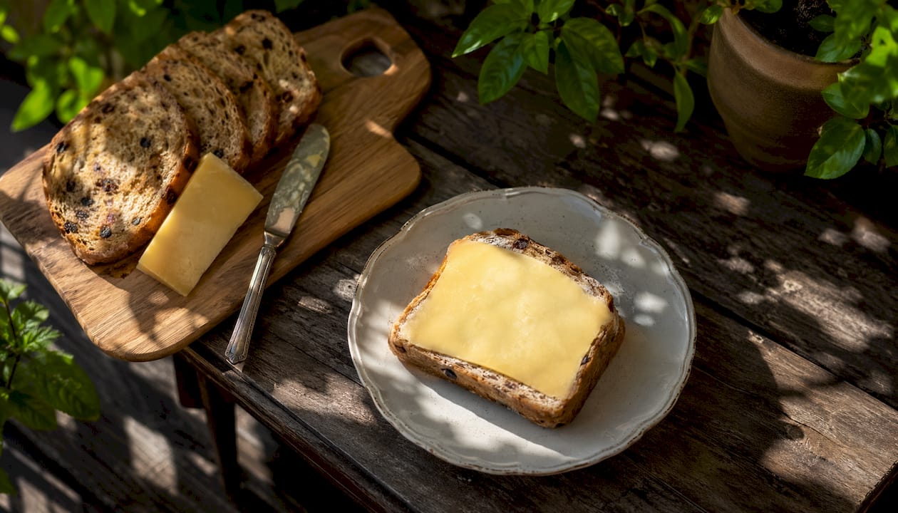 Slice of Caribbean spice bun with slab of cheese served