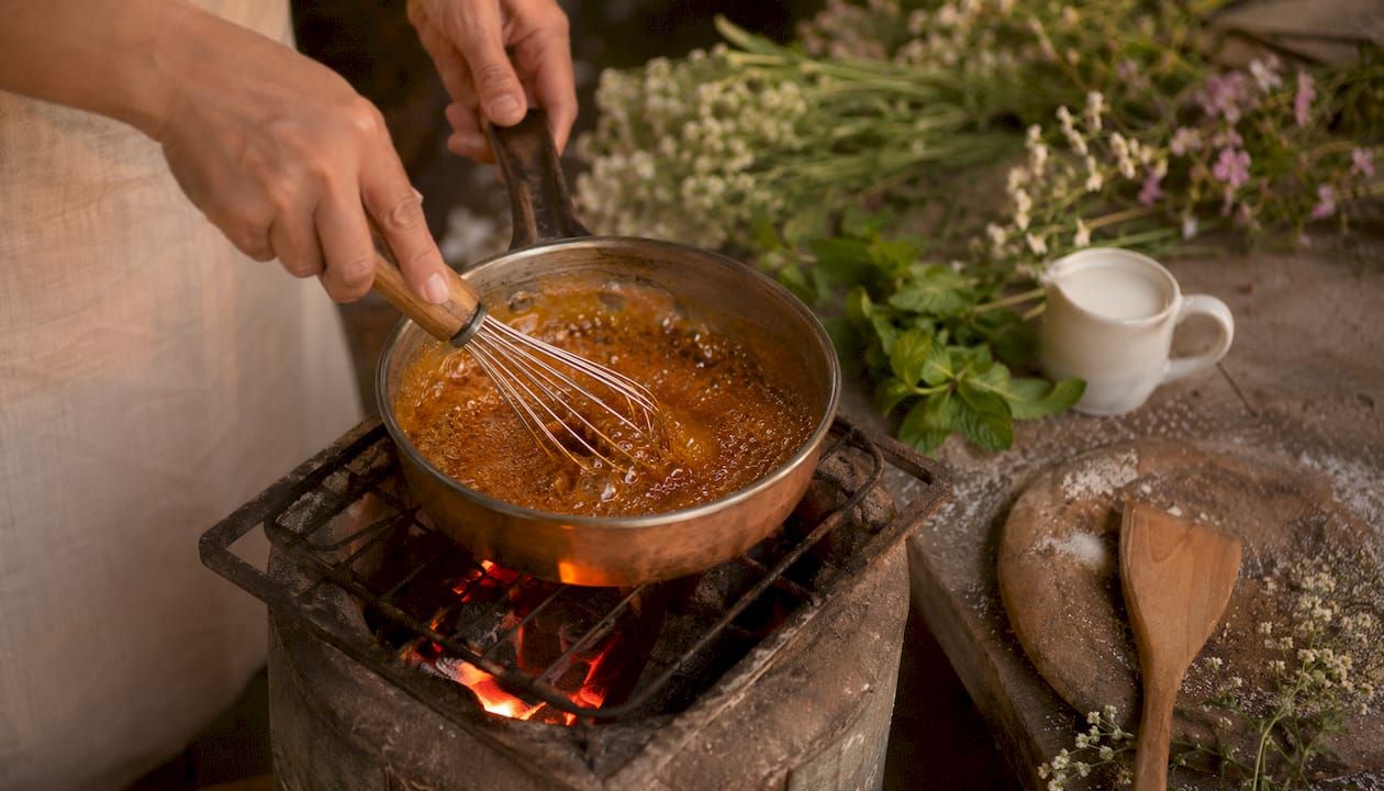 Close-up of hands stirring caramel in pan