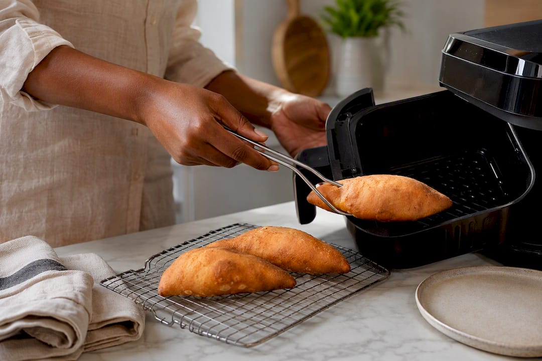 Hands reheating festival in an air fryer