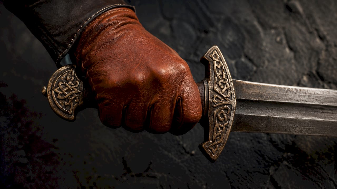 Hand holding Viking sword hilt close-up