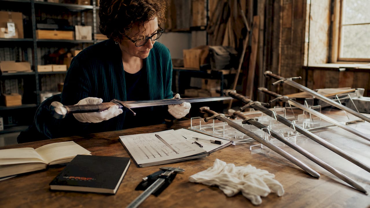 Curator examining Oakeshott sword replicas