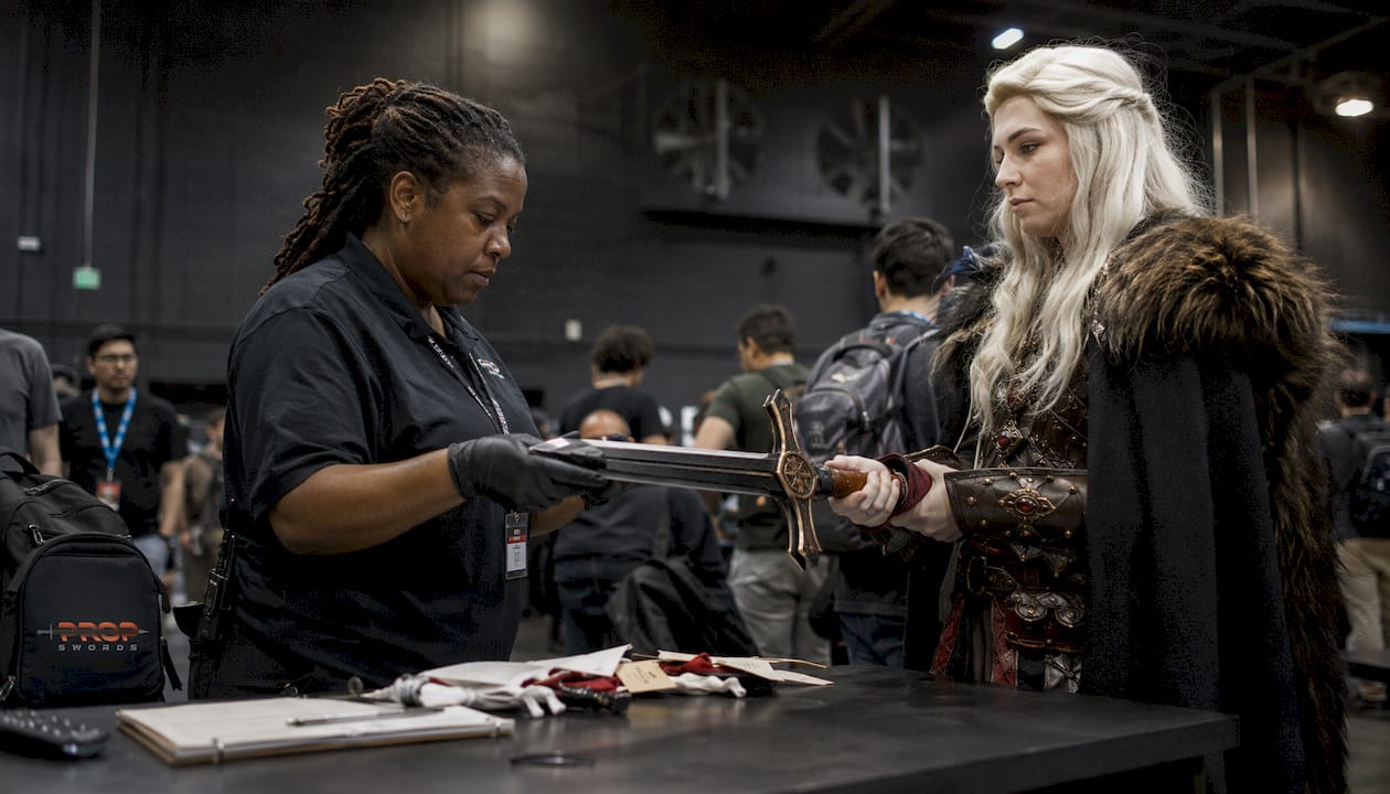 Convention staff inspecting cosplay sword prop
