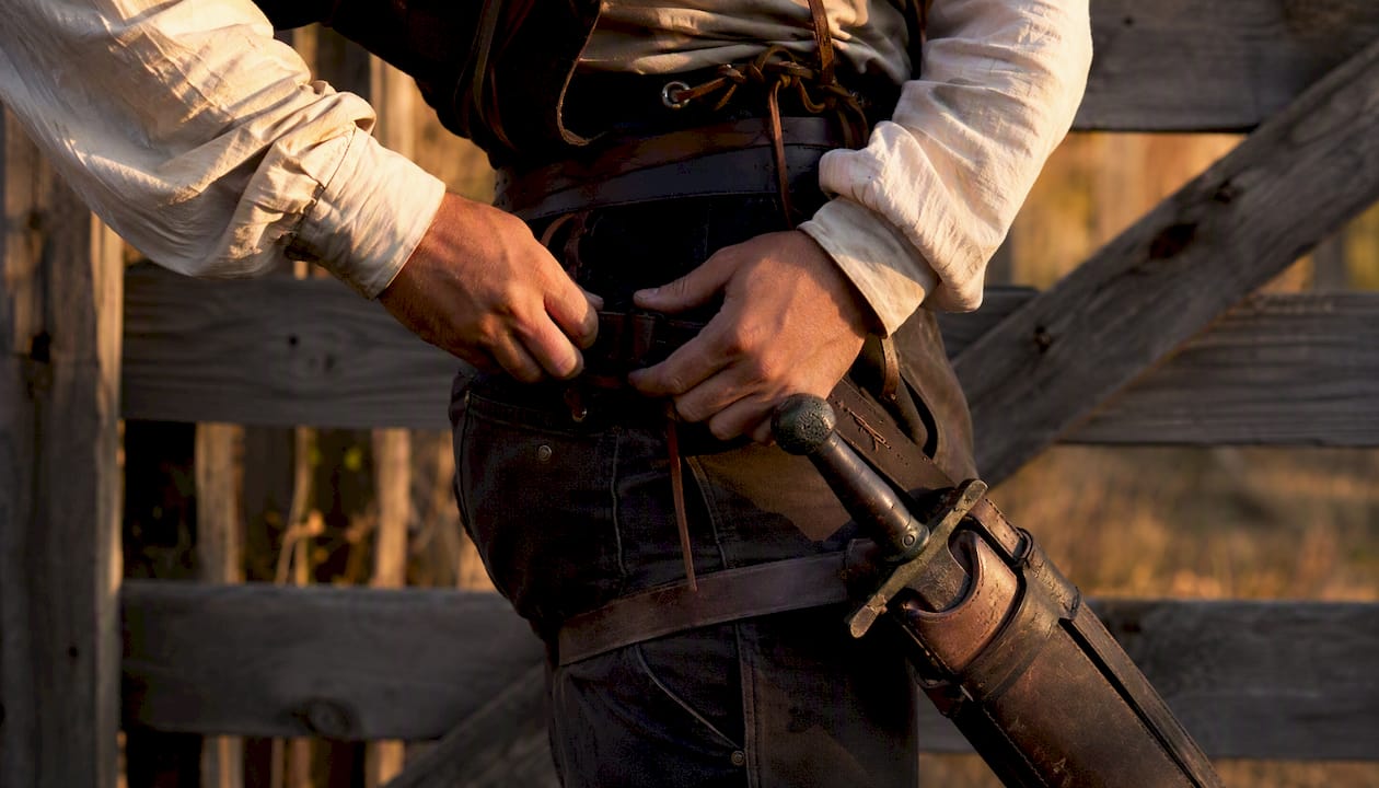 Hands adjusting sword belt outdoors