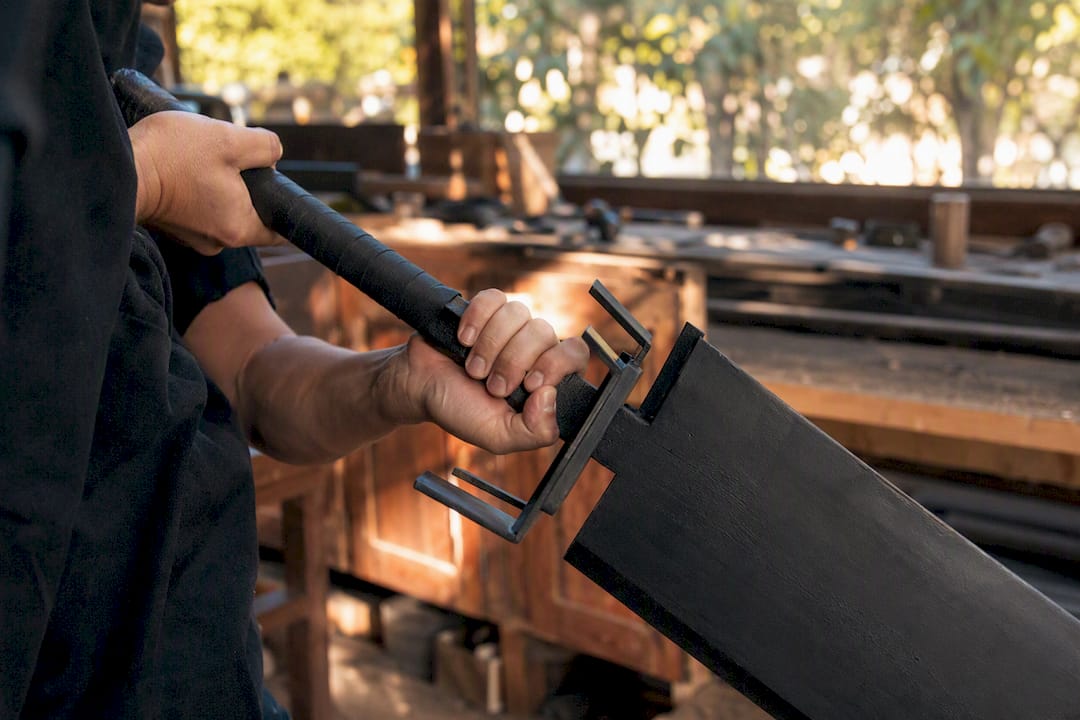 Hands holding oversized matte black zanpakuto handle