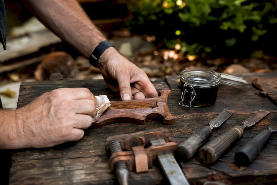 Hands finishing custom hardwood cleat sword mount