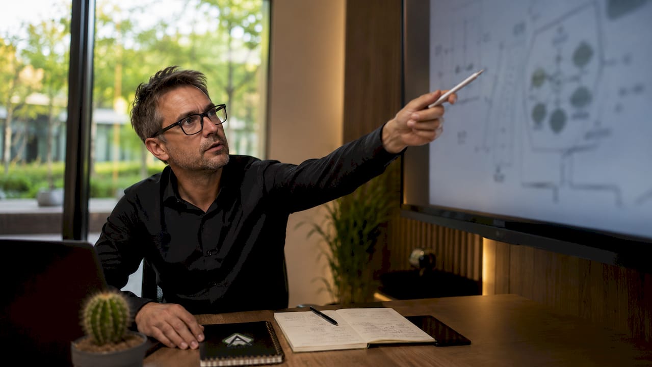 Eine Weiterbildungsmanagerin plant Schulungsmaßnahmen mithilfe eines digitalen Whiteboards.