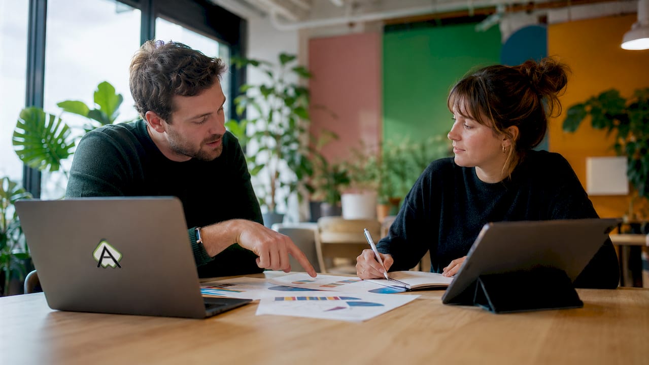 Zwei Mitarbeiter eines Start-ups tauschen sich über den Einsatz von Low-Code-Plattformen aus.