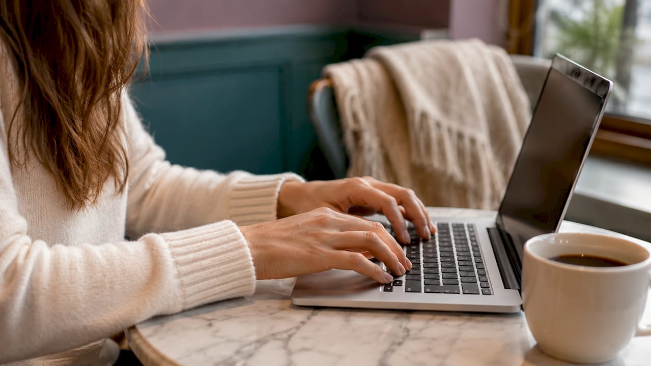 Des mains de femme en train de taper sur le clavier d’un ordinateur portable