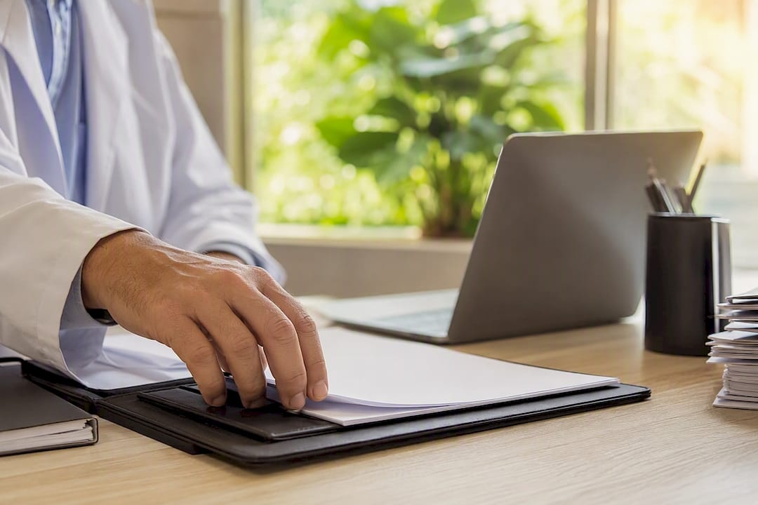 Main ajustant un dossier d'assurance vierge sur le bureau