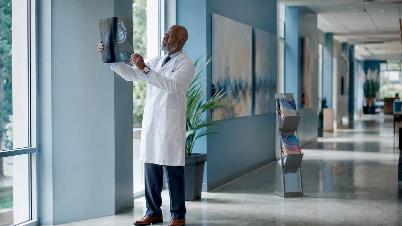 Doctor reviewing mammogram film in clinic